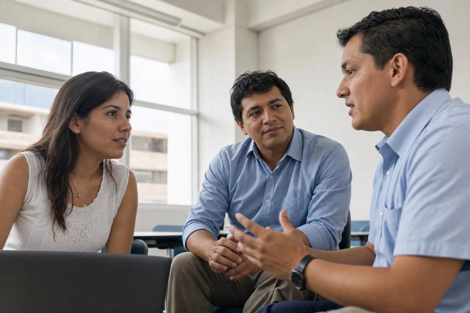Tres profesionales reunidos, uno sostiene su punto ante los demás